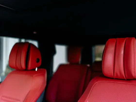 Close view of red leather vehicle seating and headrest